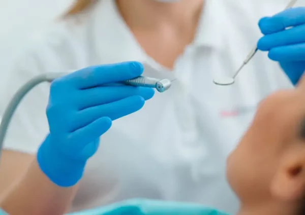 close-up-dentist-blue-rubber-gloves-holding-medical-instruments-near-face-patient-900x588